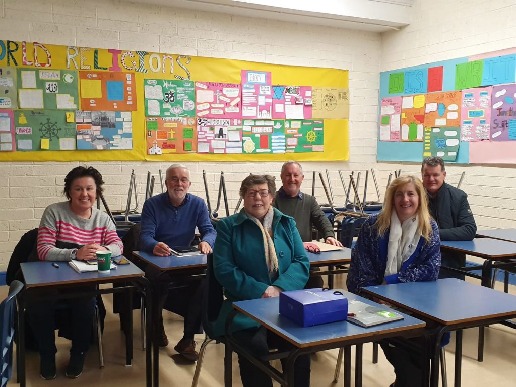 A group of happy people in a school classroom